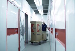 confern-Mitarbeiter verstaut Kleiderbox in Lagerraum